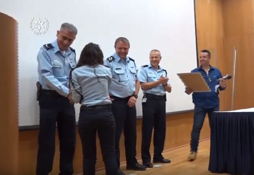 "כולם עושים את זה, גם בגילאי 11, 12, 13. רוצה לנסות? אני אלמד אותך". הסוכנת מקבלת תעודת הוקרה (צילום: דוברות המשטרה)