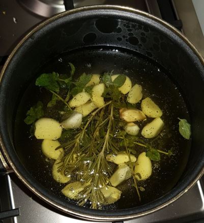 רוטב קונפי שום שמן זית רוזמרין ממתין לדג מוסר ים עטוף במלח גס שהוכנס לתנור