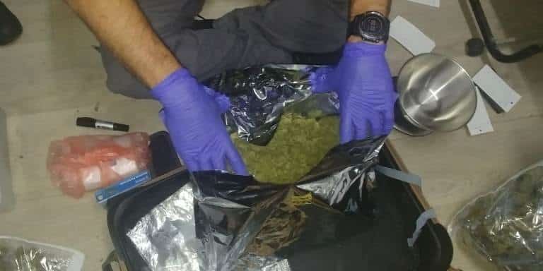 אחד השוטרים עם הסמים שנתפסו (צילומים: משטרת ישראל)