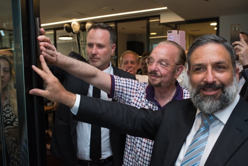 הרב אבי זרקי תוקע את המזוזה ביום הפתיחה, יום שלישי פעמיים כי טוב, לצידם של החבר הותיק עו"ד יורם שפטל והמארח