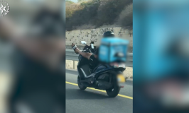 צפו: רוכב קטנוע בכביש 4 עם רגליים על הכידון